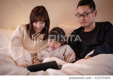 在床上躺在床上看電影的三個父母和孩子(父親,母親,女兒)的圖像(電影風格) 在床上躺在床上看電影的三個父母和孩子(父親,母親,女兒)的圖像(電影風格) 63255909