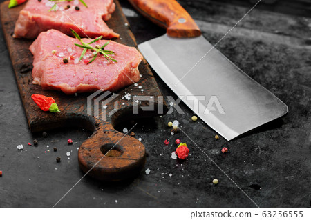 Raw beef meat with butcher knife on rustic cutting Raw beef meat with butcher knife on rustic cutting 63256555