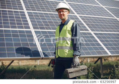 Man in a white helmet near a solar panel Man in a white helmet near a solar panel 63256997
