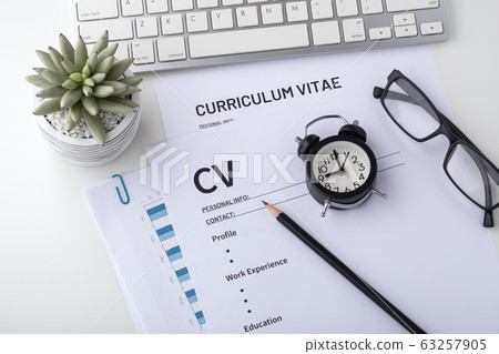 Curriculum vitae with clock on work desk Curriculum vitae with clock on work desk 63257905