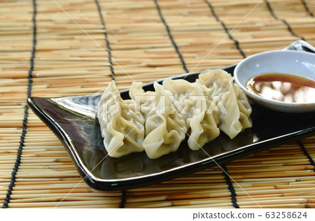 steamed Gyoza or Japanese dumpling stuffed minced pork dipping shoyu sauce on plate steamed Gyoza or Japanese dumpling stuffed minced pork dipping shoyu sauce on plate 63258624