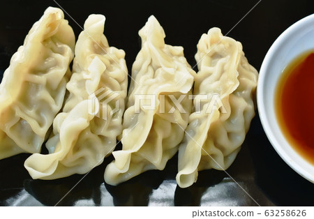 steamed Gyoza or Japanese dumpling stuffed minced pork dipping shoyu sauce on plate steamed Gyoza or Japanese dumpling stuffed minced pork dipping shoyu sauce on plate 63258626