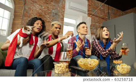 Excited group of people watching sport match, championship at home 63258718