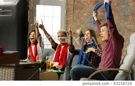 Excited group of people watching sport match, championship at home Excited group of people watching sport match, championship at home 63258728