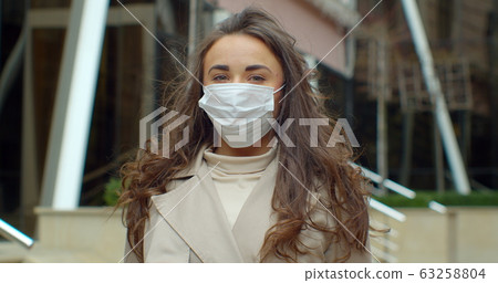 Portrait of a young student woman wearing protective mask on street.Concept of health and safety life, N1H1 coronavirus, virus protection. 63258804