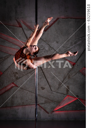 Beautiful girl training on the pole at studio 63259618