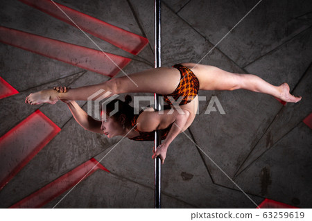 Beautiful girl training on the pole at studio 63259619