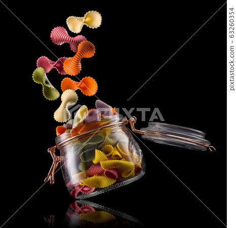 Jar of colorful farfalle pasta on wooden table isolated on black background 63260354