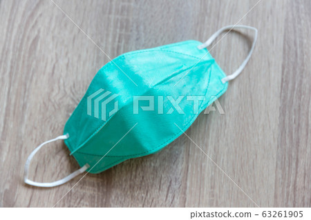 Protective face mask on wood table. 63261905