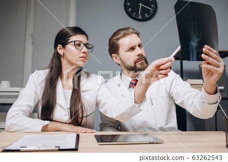 A Enthusiastic Medical Colleagues Discussing X-ray Film 63262543