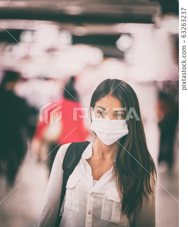 Coronavirus travel Asian woman wearing surgical face mask for virus transmission spreading prevention. Chinese girl on commute in airport flight crowded train station or public space 63263237