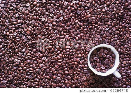 White coffee cup with coffee beans placed on spread coffee beans White coffee cup with coffee beans placed on spread coffee beans 63264748