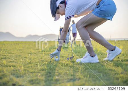 Woman golfer drop a golf ball in the rough area after lost of golf ball out of fairway 63268109