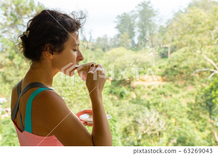 Girl drinks tea with a view of the jungle in Sri 63269043