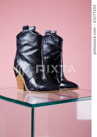 Trendy Women's boots. woman black boots on glass 63273202
