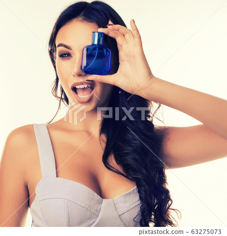 Attractive girl closes her eye with a bottle of 63275073
