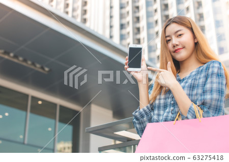 Smiling young Asian woman with shopping colour Smiling young Asian woman with shopping colour 63275418