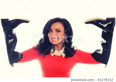 Young slim woman in red dress and brown boots Young slim woman in red dress and brown boots 63276332