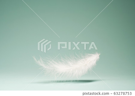 White feather, shadow on empty blue background White feather, shadow on empty blue background 63278753