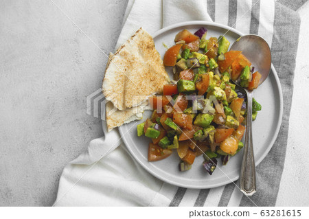 Avocado salad with tomatoes and red onions, flat lay vegan salad. Healthy vegan food. Avocado salad with tomatoes and red onions, flat lay vegan salad. Healthy vegan food. 63281615