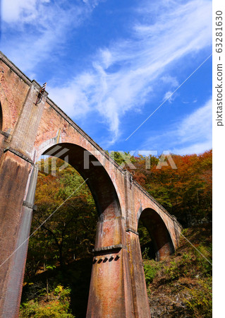 Usui third bridge of autumn leaves. Known as Megane Bridge. Annaka, Gunma, Japan. Early November. 63281630