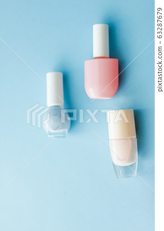 Colourful nail polish bottles on blue background, organic make-up and cosmetic products for beauty brand Colourful nail polish bottles on blue background, organic make-up and cosmetic products for beauty brand 63287679