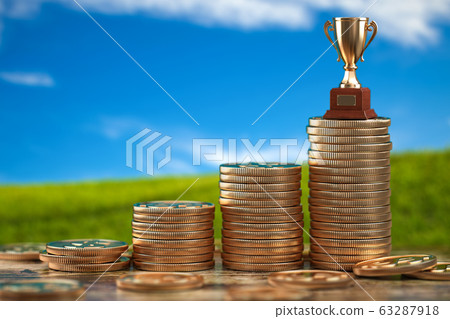 Trophy cup on stacks of coin.   Concept of 63287918