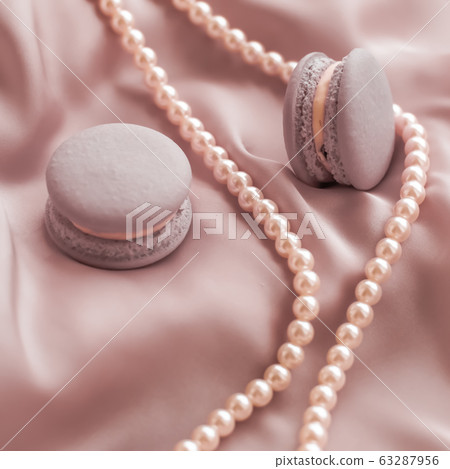Macaroons and pearl jewellery on silk fabric, luxury dessert Macaroons and pearl jewellery on silk fabric, luxury dessert 63287956