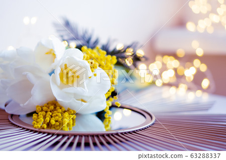 Bouquet of white tulips and mimosa flowers on mirror tray 63288337