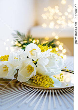 Bouquet of white tulips and mimosa flowers on mirror tray 63288343