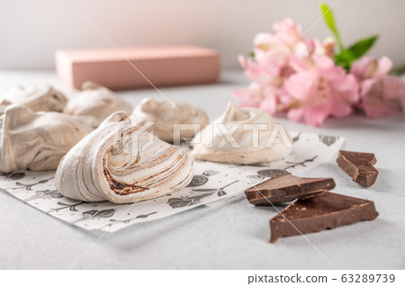 Homemade eggs dessert meringue on a light background. Next to pink flower and gift box. Copy space Homemade eggs dessert meringue on a light background. Next to pink flower and gift box. Copy space 63289739