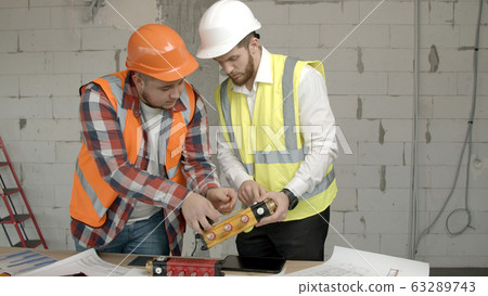Young architects checking equipment on construction site Young architects checking equipment on construction site 63289743