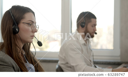 Young woman having business call in office Young woman having business call in office 63289747