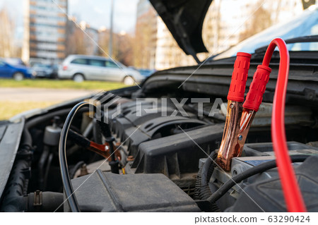 Jump cables on car battery Jump cables on car battery 63290424