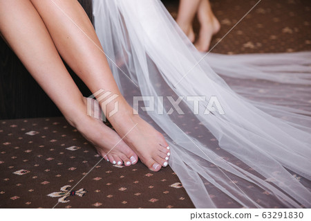 Close up of brides legs. Beautiful french pedicure Close up of brides legs. Beautiful french pedicure 63291830