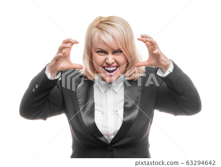 Middle aged woman is angry. The girl wearing black business suit over white background. Evil woman, hands on her sides 63294642