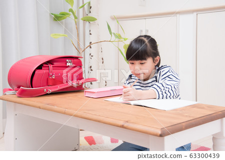 Elementary school girl making homework Elementary school girl making homework 63300439