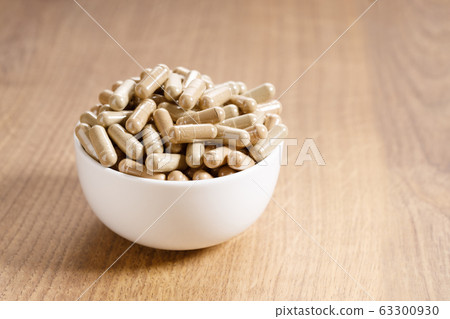 herbal pills on wooden background herbal pills on wooden background 63300930