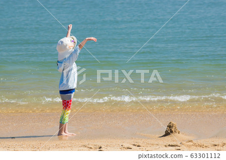 Cute child playing in the sand at the beach in early summer Cute child playing in the sand at the beach in early summer 63301112