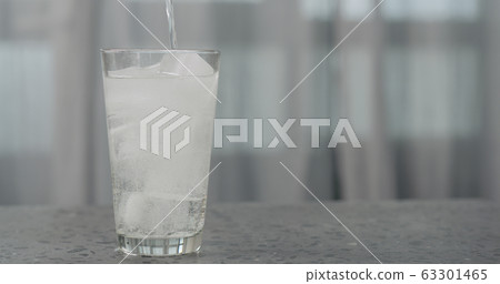 pour soda in glass with ice cubes on concrete countertop pour soda in glass with ice cubes on concrete countertop 63301465