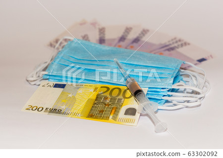 Protective medical mask, syringe vaccine and euro bills. Expensive medicine concept. Protective medical mask, syringe vaccine and euro bills. Expensive medicine concept. 63302092