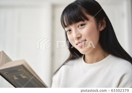 Girl reading in the living room 63302379