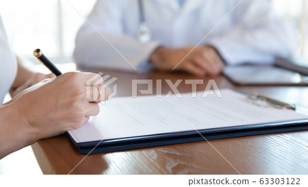 Close up young woman ready to sign medical insurance contract. 63303122