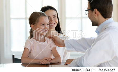 Smiling family of two visiting doctor therapist for checkup. Smiling family of two visiting doctor therapist for checkup. 63303226