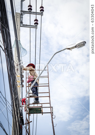 Electricians risk working install electric line 63304043