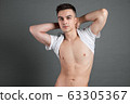 Sexy young man posing in studio. Gray background 63305367
