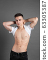 Sexy young man posing in studio. Gray background 63305387
