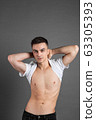 Sexy young man posing in studio. Gray background 63305393