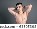 Sexy young man posing in studio. Gray background 63305398