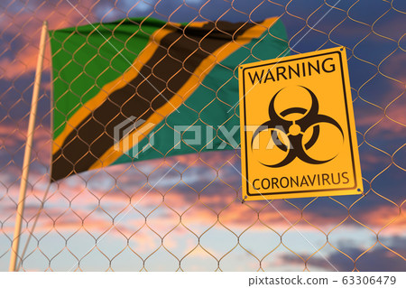 Coronavirus biohazard sign against the Tanzanian flag. Restricted border crossing or quarantine in Tanzania. Conceptual 3D rendering Coronavirus biohazard sign against the Tanzanian flag. Restricted border crossing or quarantine in Tanzania. Conceptual 3D rendering 63306479